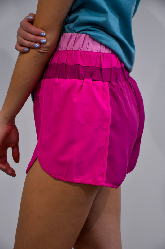 Side view of the Color Blocked Active Wear Shorts in fuchsia