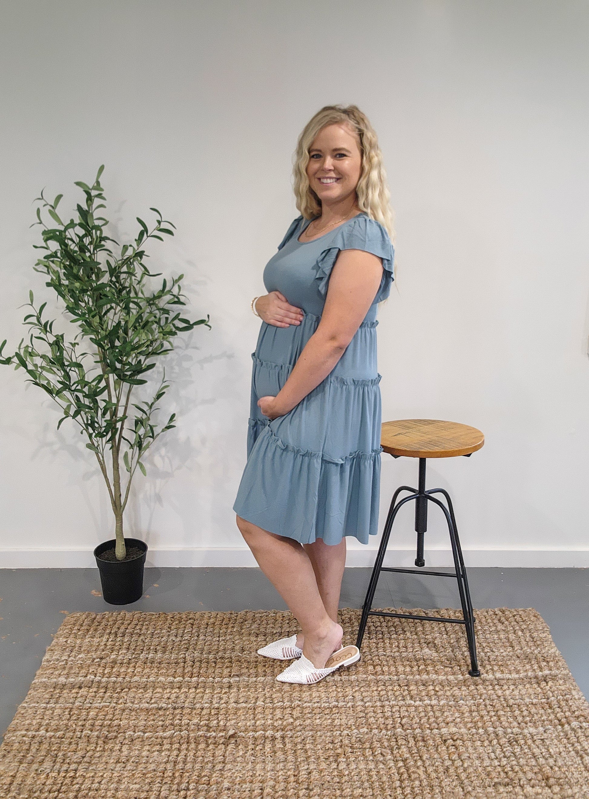 Side view of the ruffle sleeve tiered dress in blue grey showing it is maternity bump friendly